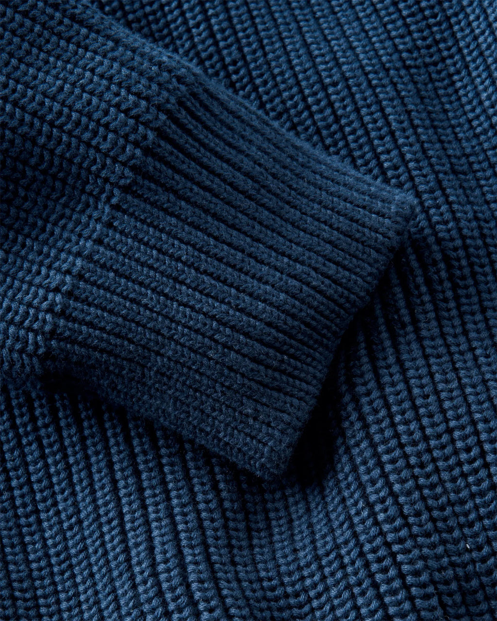 Golant Ribbed Crew strikkegenser nærbilde av Henri Lloyd-emblem