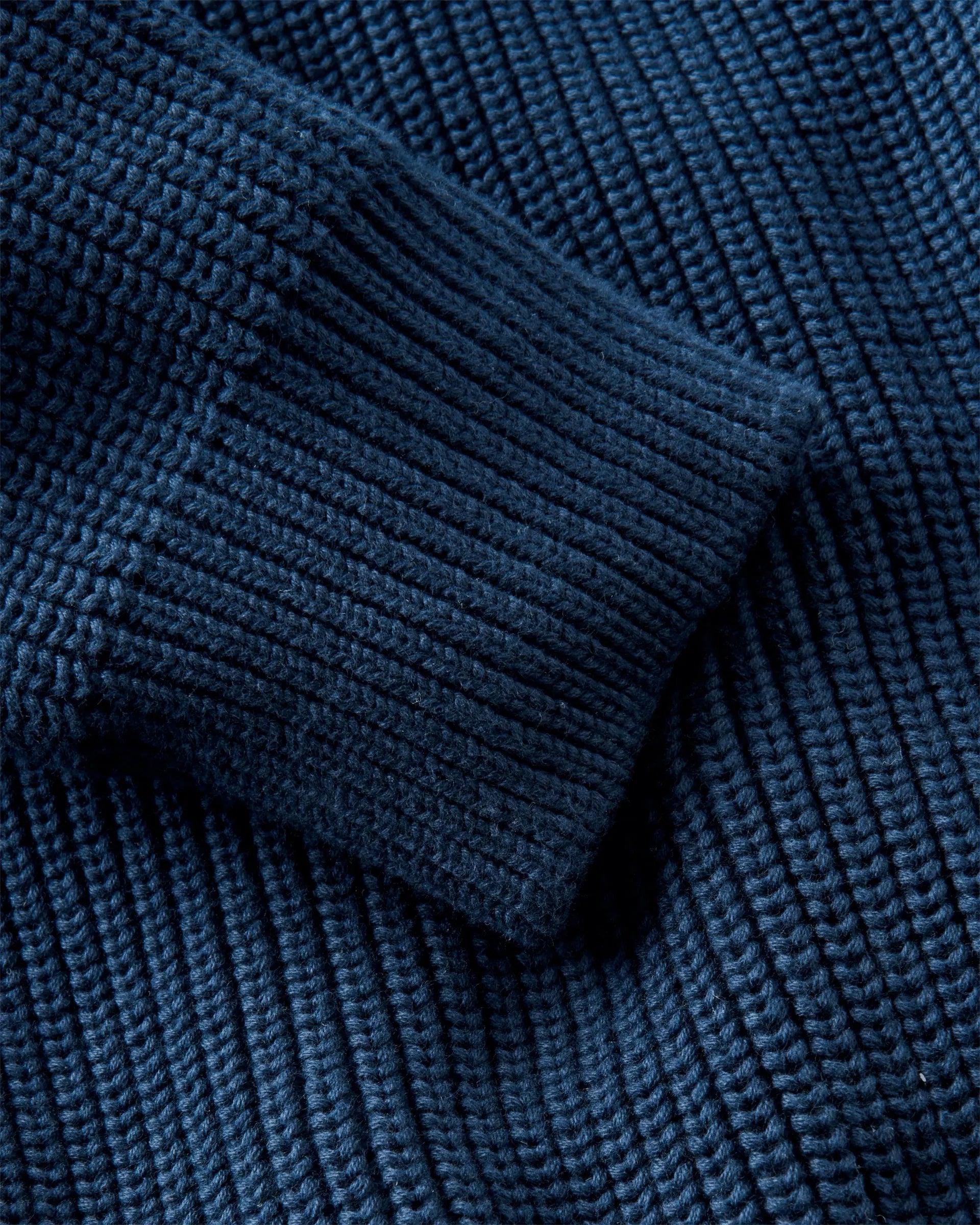 Golant Ribbed Crew strikkegenser nærbilde av Henri Lloyd-emblem