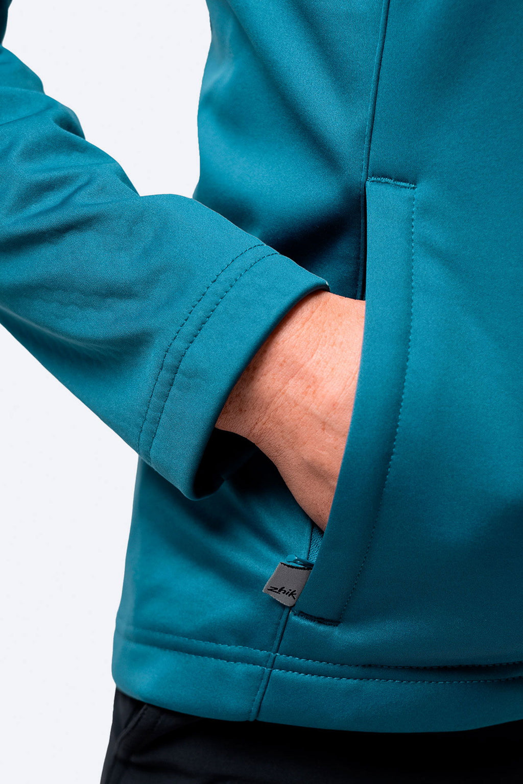 Nærbilde av logo på Tech Hoodie dame vanntett 3-lags fleecefôr mellomlag